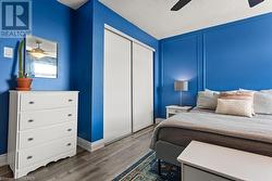 Bedroom featuring ceiling fan, wood-type flooring, a textured ceiling, and a closet - 