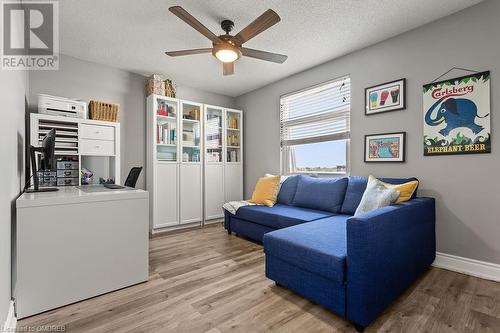 Living area featuring a textured ceiling, light wood-type flooring, and ceiling fan - 9 Bonheur Court Unit# 802, Brantford, ON 