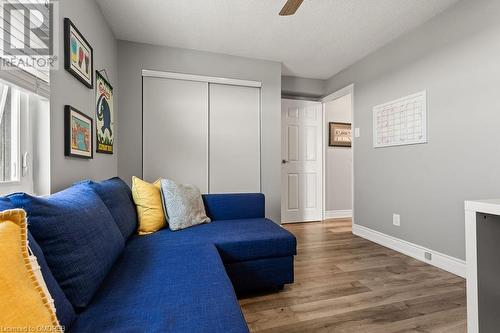 Living room with ceiling fan, a textured ceiling, and hardwood / wood-style flooring - 9 Bonheur Court Unit# 802, Brantford, ON 