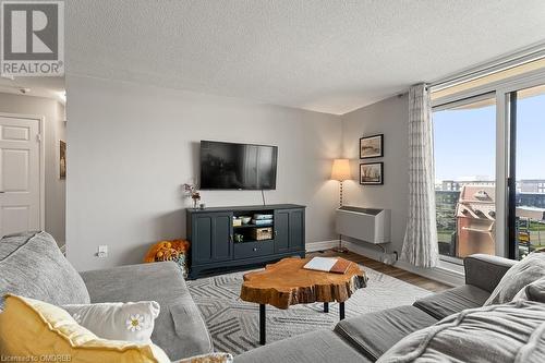 Living room featuring light wood-type flooring and a textured ceiling - 9 Bonheur Court Unit# 802, Brantford, ON 