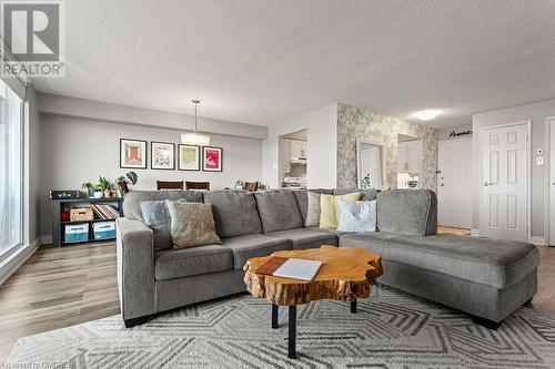 Living room with a textured ceiling and light wood-type flooring - 9 Bonheur Court Unit# 802, Brantford, ON 