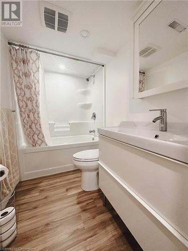 Full bathroom with hardwood / wood-style flooring, vanity, toilet, and shower / tub combo - 20 Pintail Place, Cambridge, ON 