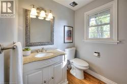 Bathroom with hardwood / wood-style floors, vanity, and toilet - 