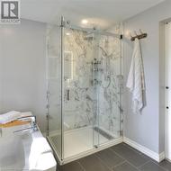 Bathroom featuring tile patterned flooring and a shower with door - 