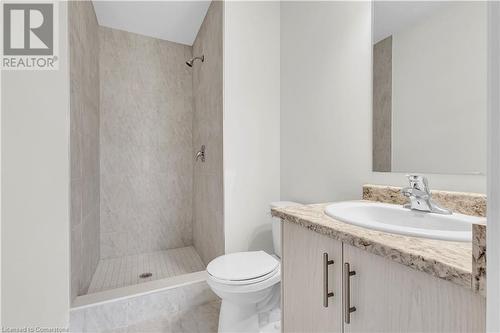 Bathroom featuring tiled shower, tile patterned floors, vanity, and toilet - 677 Park Road N Unit# 147, Brantford, ON 