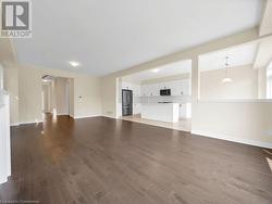 Unfurnished living room featuring dark wood-type flooring - 