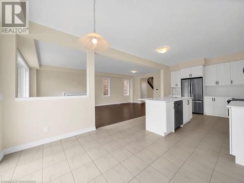 Kitchen featuring sink, hanging light fixtures, an island with sink, appliances with stainless steel finishes, and white cabinetry - 126 Broadacre Drive, Kitchener, ON 