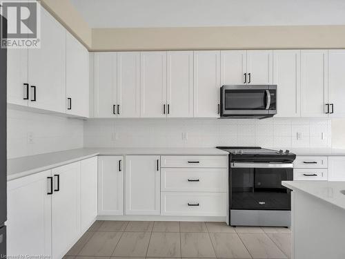 Kitchen with white cabinets and stainless steel appliances - 126 Broadacre Drive, Kitchener, ON 