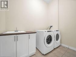 Laundry room with cabinets, sink, and washing machine and clothes dryer - 