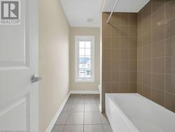 Bathroom featuring tiled shower / bath combo and toilet - 