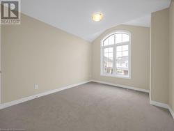 Carpeted spare room with vaulted ceiling - 