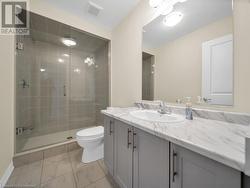 Bathroom featuring a shower with door, vanity, and toilet - 