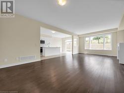 Unfurnished living room with dark hardwood / wood-style floors and sink - 