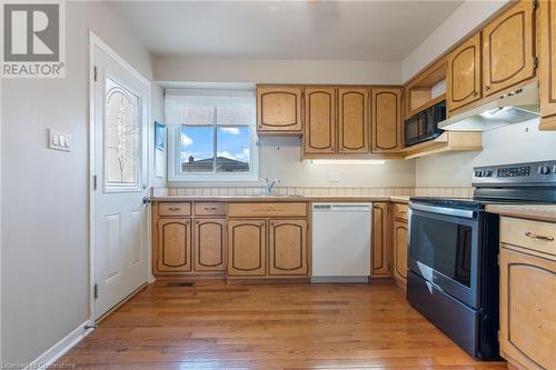 Kitchen featuring sink, dishwasher, stainless steel range with electric stovetop, and light hardwood / wood-style flooring - 118 Oak Street, Simcoe, ON 