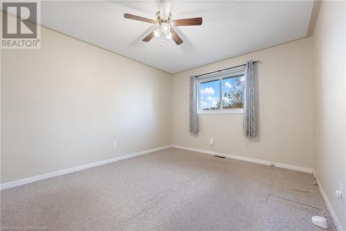 Spare room featuring a textured ceiling, carpet floors, and ceiling fan - 118 Oak Street, Simcoe, ON 