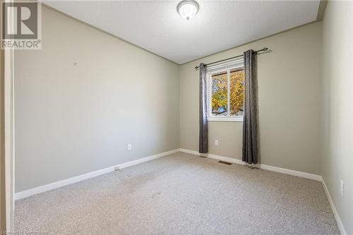 Carpeted empty room featuring a textured ceiling - 118 Oak Street, Simcoe, ON 