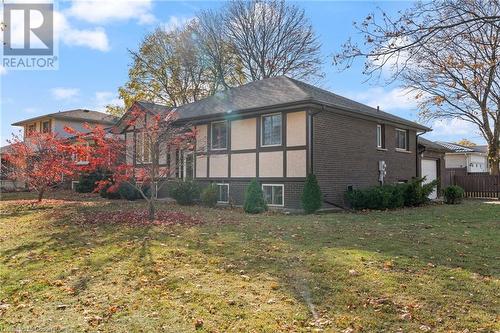 Rear view of house with a garage and a lawn - 118 Oak Street, Simcoe, ON 