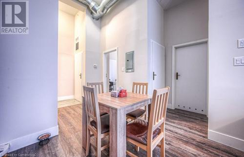 Dining area featuring electric panel, wood-type flooring, and a high ceiling - 253 Albert Street N Unit# 104, Waterloo, ON - Indoor Photo Showing Dining Room