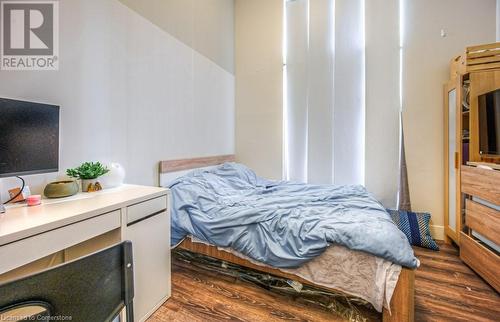 Bedroom featuring dark hardwood / wood-style floors - 253 Albert Street N Unit# 104, Waterloo, ON - Indoor Photo Showing Bedroom With Fireplace