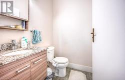 Bathroom featuring wood-type flooring, vanity, and toilet - 