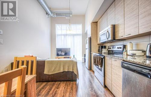 Kitchen with appliances with stainless steel finishes, dark hardwood / wood-style flooring, light stone counters, and light brown cabinets - 253 Albert Street N Unit# 104, Waterloo, ON - Indoor Photo Showing Kitchen