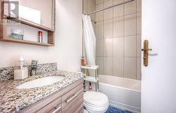 Full bathroom featuring shower / tub combo with curtain, vanity, and toilet - 