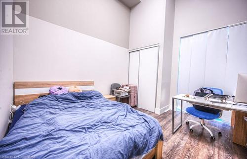 Bedroom with hardwood / wood-style flooring, a towering ceiling, and a closet - 253 Albert Street N Unit# 104, Waterloo, ON - Indoor Photo Showing Bedroom