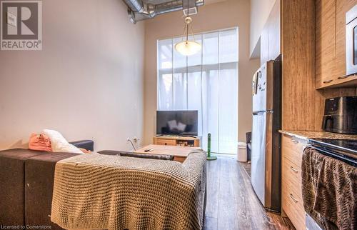 Bedroom with stainless steel refrigerator and dark wood-type flooring - 253 Albert Street N Unit# 104, Waterloo, ON - Indoor