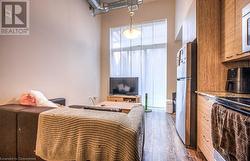 Bedroom with stainless steel refrigerator and dark wood-type flooring - 