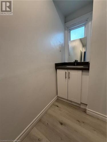 Bathroom featuring hardwood / wood-style floors and sink - 485 Main Street E Unit# 2, Hamilton, ON - Indoor Photo Showing Other Room