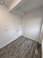 Unfurnished room featuring dark hardwood / wood-style floors - 