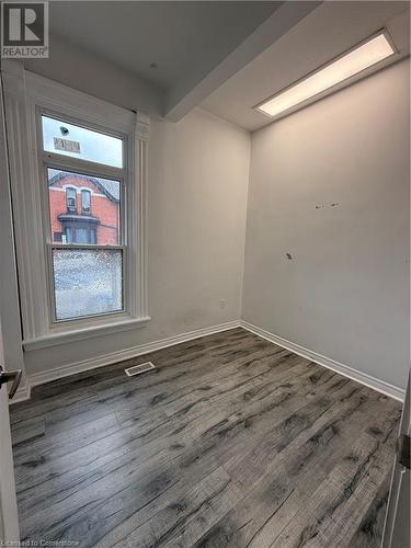 Empty room with beam ceiling and dark hardwood / wood-style floors - 485 Main Street E Unit# 2, Hamilton, ON - Indoor Photo Showing Other Room