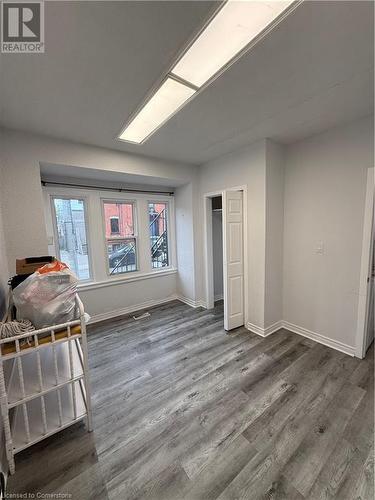 Unfurnished bedroom featuring dark wood-type flooring - 485 Main Street E Unit# 2, Hamilton, ON - Indoor Photo Showing Other Room