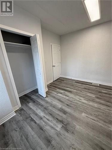 Unfurnished bedroom featuring dark hardwood / wood-style floors and a closet - 485 Main Street E Unit# 2, Hamilton, ON - Indoor Photo Showing Other Room