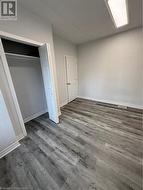 Unfurnished bedroom featuring dark hardwood / wood-style floors and a closet - 