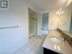 Bathroom featuring tile patterned flooring, vanity, and a shower with shower door - 