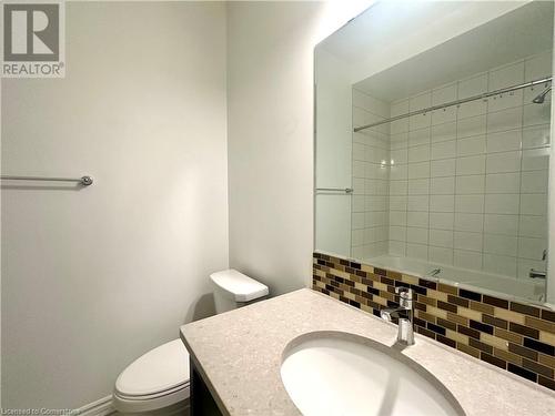 Bathroom featuring vanity, a tile shower, backsplash, and toilet - 94 Milt Schmidt Street, Kitchener, ON - Indoor Photo Showing Bathroom