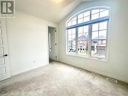 Empty room with lofted ceiling, light carpet, and a wealth of natural light - 