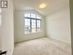 Carpeted spare room featuring vaulted ceiling - 