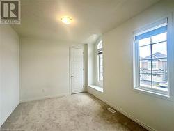 Empty room featuring a textured ceiling, light carpet, and a wealth of natural light - 