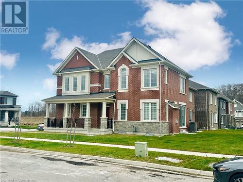 View of front facade featuring a porch, cooling unit, and a front lawn - 94 Milt Schmidt Street, Kitchener, ON - Outdoor With Facade