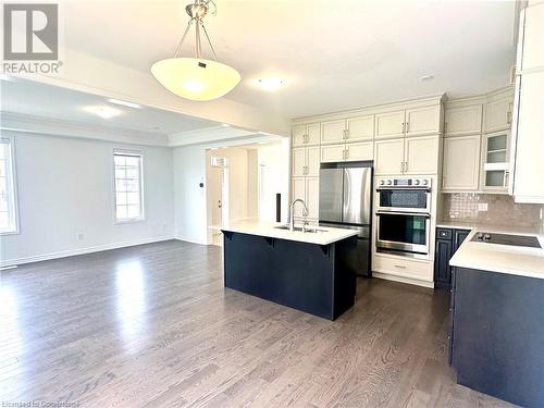 Kitchen featuring sink, appliances with stainless steel finishes, decorative light fixtures, a kitchen island, and dark hardwood / wood-style flooring - 94 Milt Schmidt Street, Kitchener, ON - Indoor Photo Showing Kitchen With Upgraded Kitchen