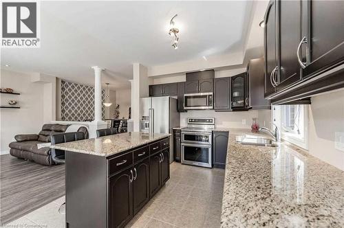 Kitchen featuring ornate columns, light stone countertops, sink, stainless steel appliances, and a kitchen island - 243 Greenwater Place Unit# Upper, Kitchener, ON - Indoor Photo Showing Kitchen With Upgraded Kitchen