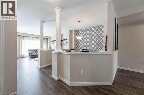 Kitchen with ornate columns, hanging light fixtures, dark wood-type flooring, kitchen peninsula, and a textured ceiling - 243 Greenwater Place Unit# Upper, Kitchener, ON - Indoor