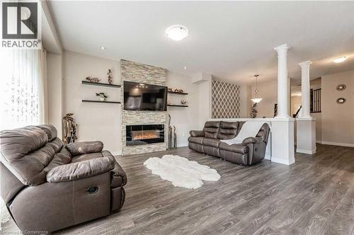 Living room with wood-type flooring, a fireplace, and decorative columns - 243 Greenwater Place Unit# Upper, Kitchener, ON - Indoor Photo Showing Living Room With Fireplace