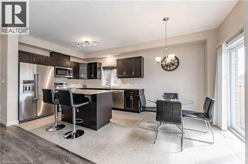 Kitchen featuring hanging light fixtures, a chandelier, a kitchen bar, dark brown cabinets, and appliances with stainless steel finishes - 243 Greenwater Place Unit# Upper, Kitchener, ON - Indoor