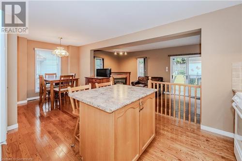 Kitchen with a center island, light brown cabinets, light wood-type flooring, decorative light fixtures, and a chandelier - 435 Shadow Wood Crescent, Waterloo, ON - Indoor