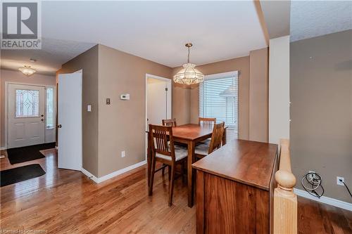 Dining space with a chandelier, a textured ceiling, and light wood-type flooring - 435 Shadow Wood Crescent, Waterloo, ON - Indoor Photo Showing Dining Room