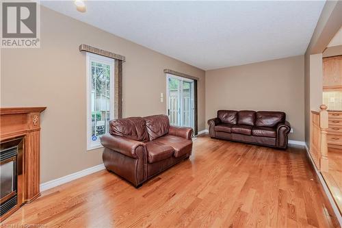 Living room with plenty of natural light and light hardwood / wood-style flooring - 435 Shadow Wood Crescent, Waterloo, ON - Indoor Photo Showing Living Room With Fireplace