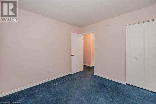 Unfurnished bedroom with a closet and dark colored carpet - 435 Shadow Wood Crescent, Waterloo, ON - Indoor Photo Showing Other Room